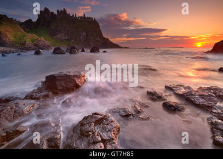 Les ruines de la château de Dunluce sur la côte de Causeway d'Irlande du Nord. Photographié au coucher du soleil. Banque D'Images