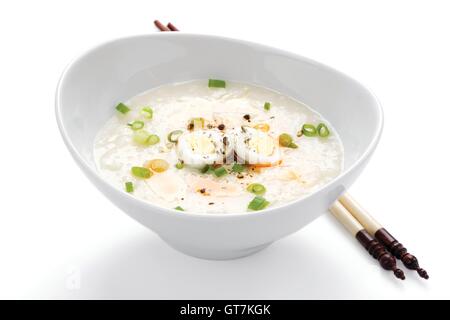 Délicieux avec des baguettes de congee chinois sur fond blanc Banque D'Images