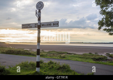 Inscrivez-Fingerpost affichage des distances à Wallsend, Maryport et Rome Solway Firth au coucher du soleil, Bowness-on Solway, Cumbria, Angleterre Banque D'Images