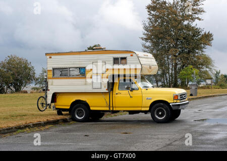 Garé des années 1990 Ford F250 jaune camionnette avec un camping-car à Vancouver, Colombie-Britannique, Canada Banque D'Images