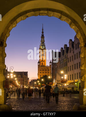 Les gens qui marchent à travers l'arche de la porte verte sur la rue Długa dans la vieille ville de Gdansk, avec Muzeum Historyczne Miasta Gdańska située et fontaine de Neptune Banque D'Images