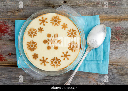 High Angle View of Gourmet Dessert semoule au lait servi dans un bol en verre sur le dessus d'une table en bois rustique avec serviette et Spo Banque D'Images