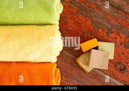 Close up Vue aérienne de l'authentique savon fait à la main et serviettes de couleur claire sur le dessus d'une table en bois rustique. Banque D'Images
