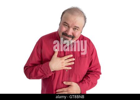 D'âge moyen Ingratiating homme chauve avec un bouc montrant sa gratitude avant de flexion avec sa main à son cœur et un moyens Banque D'Images