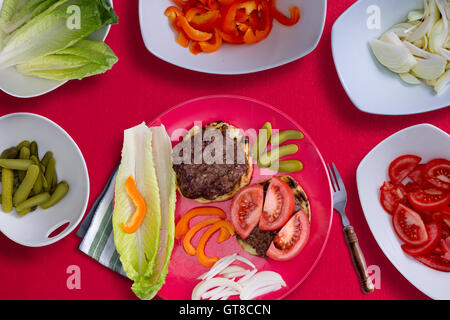 Créer le parfait hamburger sain avec deux galettes de boeuf grillé avec des tranches de pains sur des ingrédients frais sucrés peppe Banque D'Images