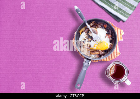 Sunny Side Up omelette sur Violet Color Table Cloth avec une tasse de thé chaud, Mason copie espace laissé à gauche Banque D'Images