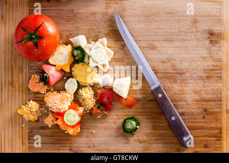 Déchets organiques provenant des légumes et épices, peuvent être utilisés pour le compost, terre de jardin sur le dessus de planche à découper en bois avec couteau de cuisine. Banque D'Images