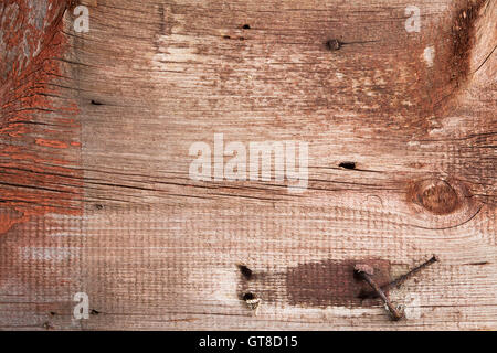 Old weathered wood texture battues avec des clous rouillés, des taches et des vestiges de la peinture d'un bâtiment démoli Banque D'Images