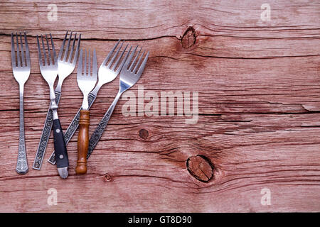 Pile aléatoire de fourches rustique organisé sur le côté d'une table en bois rustique avec copyspace dans un concept de pays Pommes de terre In Cuisin Banque D'Images