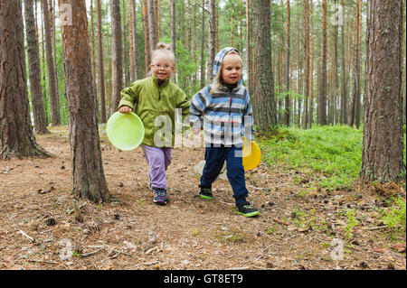 4 ans, frère et sœur à marcher avec leurs disques volants à travers les bois, Suède Banque D'Images