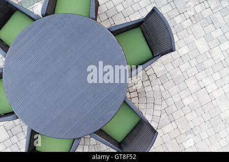 Six places ensemble patio extérieur avec de confortables coussins vert et une table à manger ronde sur un pavé de brique avec patio en plein air copie Banque D'Images