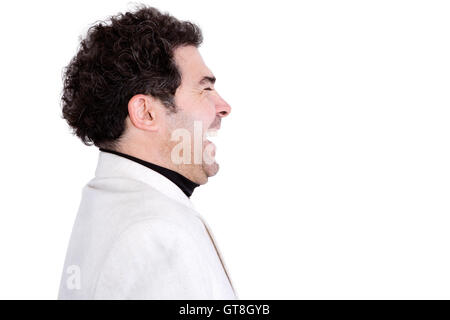 Vue sur le côté isolé de l'attrayant, mâle d'âge moyen avec des cheveux bouclés et veste blanche laughing Banque D'Images