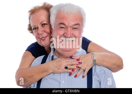 Smiling mari en pinstripe shirt avec bretelles câlins par une heureuse femme par derrière sur fond blanc Banque D'Images