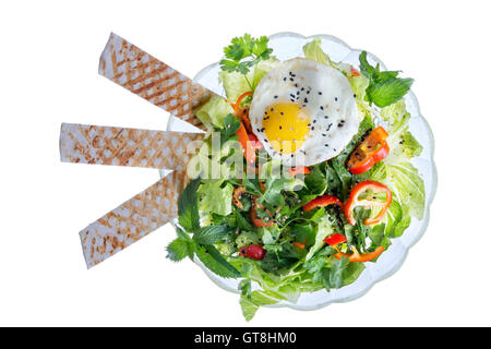 Angle de vue de la vie encore élevé de salade verte faite avec des légumes frais et garnie d'oeufs frits et de pain lavash, Banque D'Images