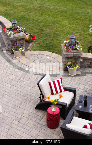 High Angle View of Luxury patio avec meubles de salon en plein air et des piliers de pierre décorée de fleurs colorées - Vin Rouge Banque D'Images