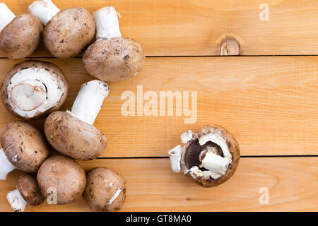 Bébé Bio frais champignons bella pour utilisation comme ingrédient dans la cuisine savoureuse et des salades sur une table de cuisine en bois, vue d'un Banque D'Images