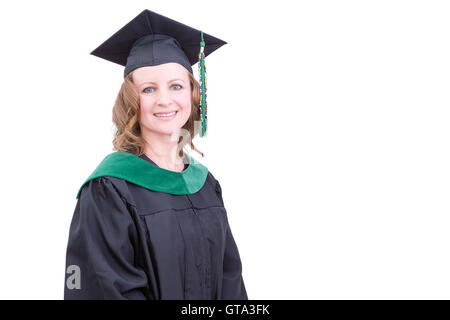 Jolie universitaire d'âge moyen à l'obtention du diplôme les vêtements portant un mortier cap and gown regardant la caméra avec un heureux heureux Banque D'Images