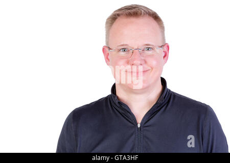 Attractive blonde homme portant des lunettes avec un véritable sourire amical et les yeux verts à directement à l'appareil photo, la tête et le shoul Banque D'Images