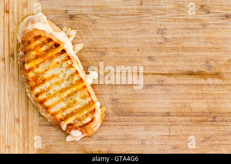 Panini grillé appétissant pain italien sandwich au fromage avec du fromage fondant sur une planche à découper en bambou avec copie espace, les frais généraux Banque D'Images