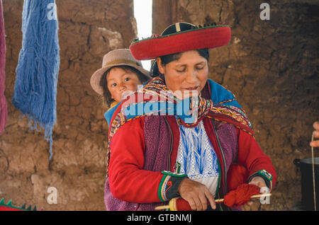 Femme autochtone vêtu de vêtements colorés traditionnels expliquant les threads de teinture et de tissage Banque D'Images