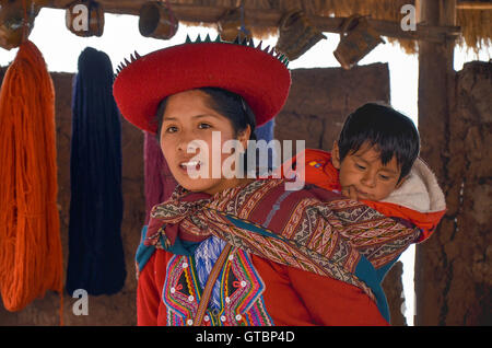 Femme autochtone vêtu de vêtements colorés traditionnels expliquant les threads de teinture et de tissage Banque D'Images