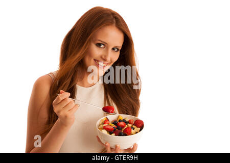 Une saine alimentation - femme mange un bol de salade de fruit isolated over white background - végétarien Banque D'Images