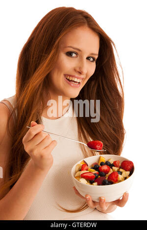 Une saine alimentation - femme mange un bol de salade de fruit isolated over white background - végétarien Banque D'Images