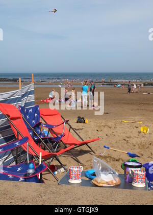 S'alimentaient les algues, Union Jack et Marks and Spencer traite. Une famille de classe moyenne met en place le camp sur la plage de la baie nord de Scarborough Banque D'Images