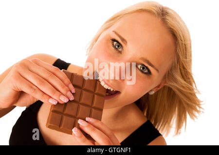 Belle jeune femme mange isolés chocolat over white background Banque D'Images