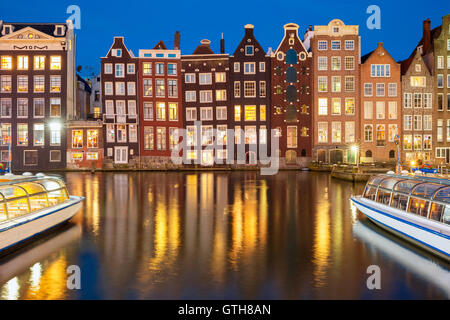 Nuit dansant à maisons du canal d'Amsterdam, la Damrak, en Hollande, aux Pays-Bas. Banque D'Images