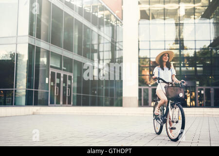 Belle femme à l'aide de vélo au lieu de location Banque D'Images