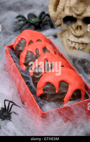 Zephyr en lustre de chocolat avec des rayures d'une sanglante la table sur l'Halloween Banque D'Images