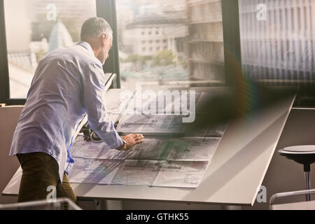 Architect reviewing blueprints in office Banque D'Images