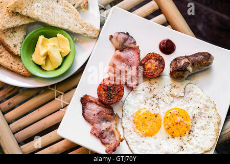 English british classique petit-déjeuner avec des oeufs au plat bacon saucisse tomates et toasts définir Banque D'Images