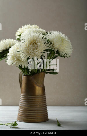 Fleurs blanches en cruche sur table en bois, asters Banque D'Images