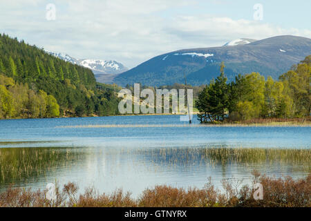 Vue sur le loch dans le parc national de Cairngorm, montrant les montagnes enneigées Banque D'Images