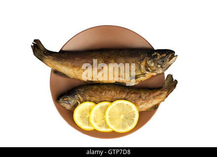 Sur la table en bois est une plaque avec deux truite poisson au four avec du citron Banque D'Images