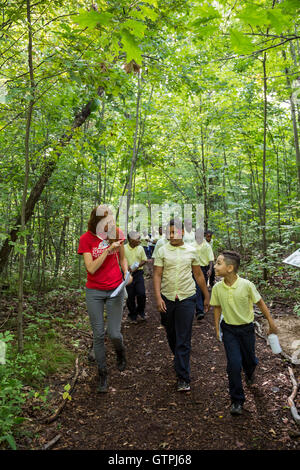 Detroit, Michigan - 5e année Les élèves de l'école élémentaire Dixon, randonnée pédestre sur le pont de pierre Sentier Nature dans le parc de la Rouge. Banque D'Images