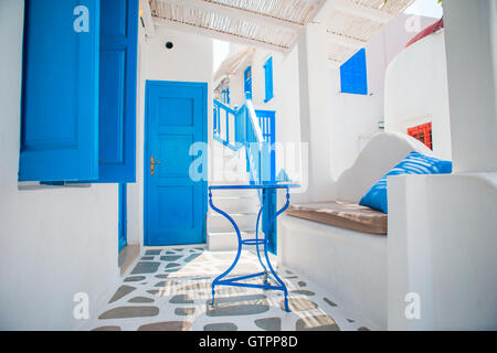 Les rues étroites de l'île avec des balcons bleus, des escaliers et des fleurs. Belle terrasse extérieur avec le style des Cyclades. Banque D'Images