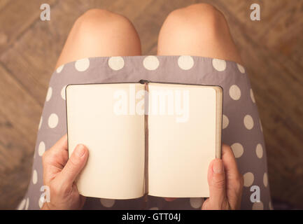 Femme tenant un ordinateur portable avec des pages blanches Banque D'Images