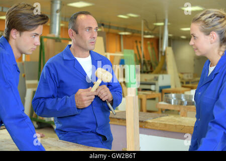 Carpenter avec les apprentis masculins et féminins Banque D'Images