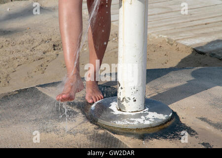 Femme d'avant-plan pieds prendre une douche dans la plage Banque D'Images