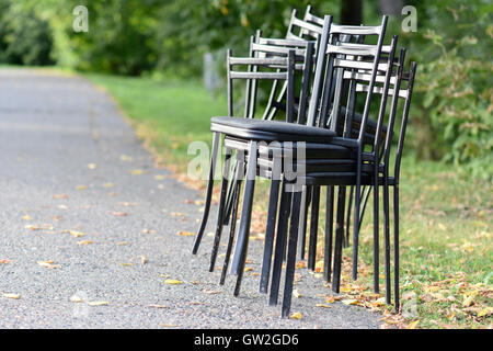 Chaises métalliques empilés sur le côté de la route Banque D'Images