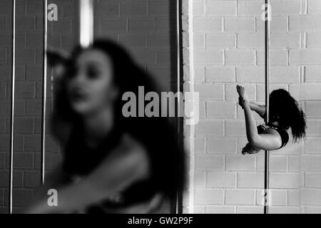 Carolina Echavarria, une jeune danseuse pole colombien, tourne autour d'un poteau pendant une session de formation dans le milieu universitaire Pin Up à Medellín, Colombie. Banque D'Images