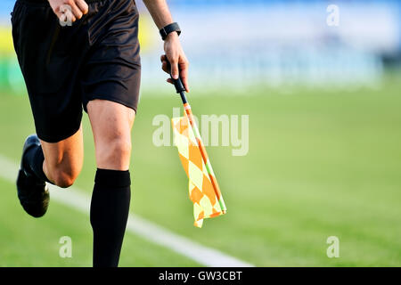 Arbitre Assistant se déplaçant le long de la ligne de côté pendant un match de foot Banque D'Images