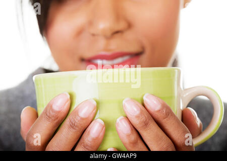 Jeune femme à boire quelque chose de grand mug Banque D'Images