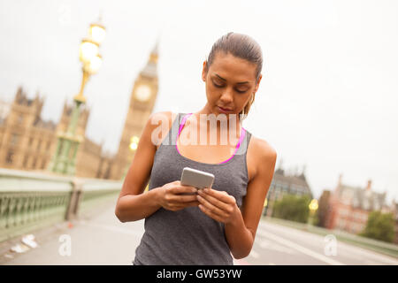 Femme de remise en forme à Londres contrôler son téléphone Banque D'Images