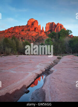 Cathedral Rock au coucher du Soleil reflété dans une flaque d'eau près de Oak Creek à Sedona, Arizona Banque D'Images