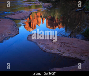 Cathedral Rock au coucher du soleil reflétée dans les eaux calmes d'Oak Creek à Sedona, Arizona Banque D'Images