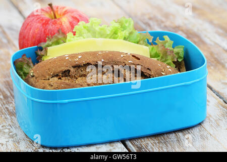 Lunch Box contenant Brown sandwich au fromage et pomme rouge sur la surface en bois rustique Banque D'Images